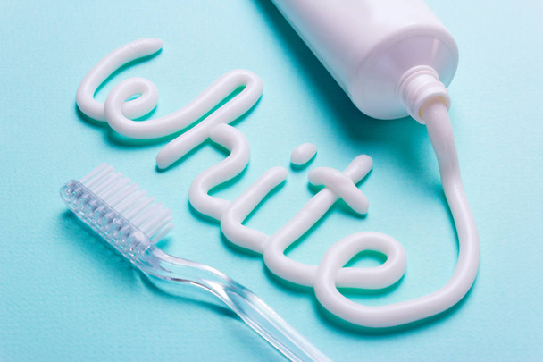 La palabra blanco es de la pasta de dientes. Tubo y cepillo de dientes para la limpieza de dientes y blanqueamiento
 - Foto, Imagen
