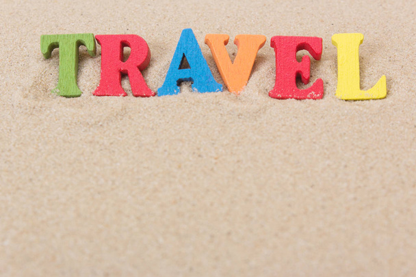 Viaggio parola di lettere di legno colorate sulla spiaggia di sabbia
 - Foto, immagini