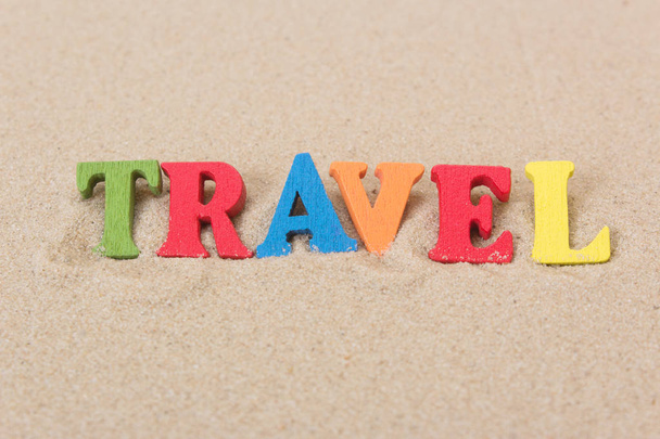 Λέξη ταξίδι χρωματιστά ξύλινα γράμματα σε αμμώδη παραλία - Φωτογραφία, εικόνα
