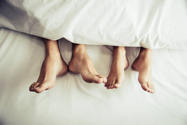 Ξυπόλυτος εραστές κάτω από κουβέρτα στο υπνοδωμάτιο. Διακοπές και ευτυχία της σεξουαλικής. Θέμα ημέρα του Αγίου Βαλεντίνου. Το πρωί θέμα των διακοπών - Φωτογραφία, εικόνα