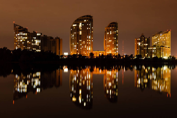 νύχτα πόλη με αντανάκλαση των σπιτιών στο ποτάμι - Φωτογραφία, εικόνα