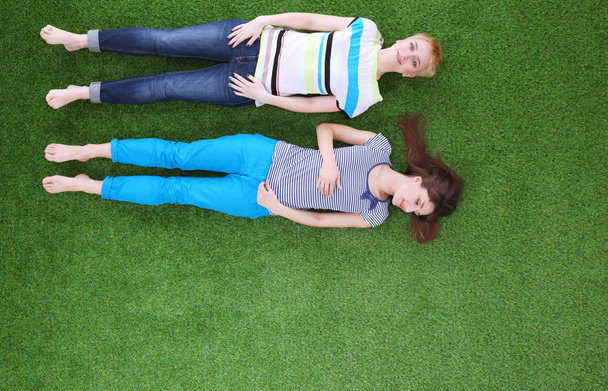 Young women lying on green grass . Young women - 写真・画像