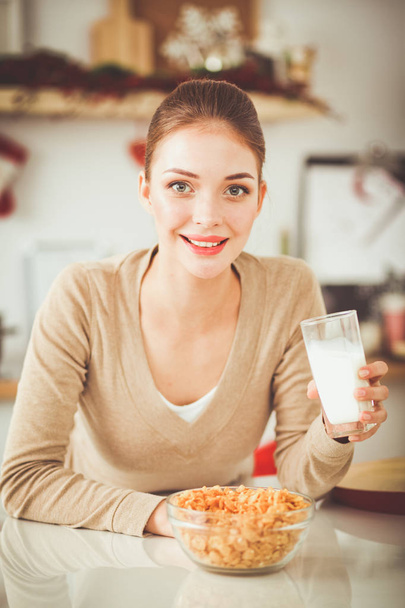 Smiling attractive woman having breakfast in kitchen interior. Smiling attractive woman. - Foto, imagen