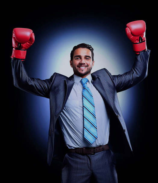 Businessman in a suit and boxing gloves, celebrating a win. - Фото, зображення