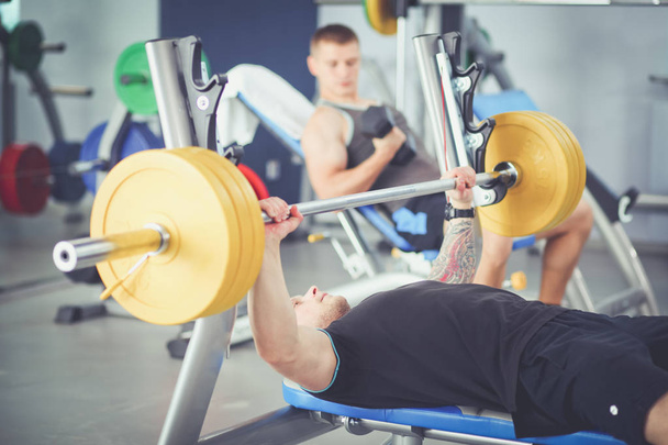 Bodybuilder with barbell in gym. Bodybuilder - Foto, Imagen