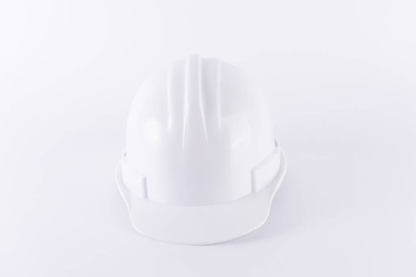 Λευκό προστατευτικού κράνους σε άσπρο φόντο. Σκληρό καπέλο και χοντρά γάντια σε άσπρο φόντο απομονωμένες. Εξοπλισμός αλείας. Εργαζόμενος και βιομηχανική θέμα. - Φωτογραφία, εικόνα
