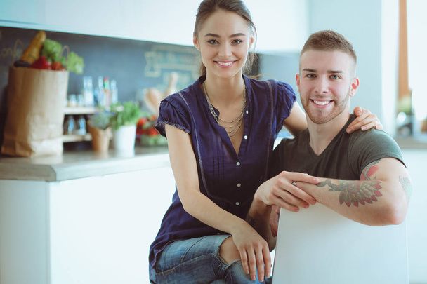Beautiful young couple is having fun in kitchen at home - Foto, imagen