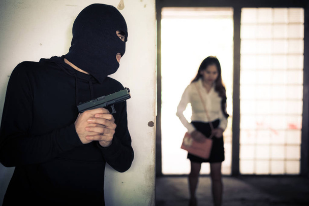 Dayanabiliyor ve kadın onun cüzdan veya el çalmak için bekliyor soyguncu el ile silah binanın köşesindeki çanta. Suç cinsel ve tehlikeli yasadışı şiddet kriz kavramı - Fotoğraf, Görsel