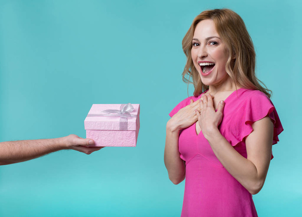 Cheerful young woman getting gift from man - Фото, изображение