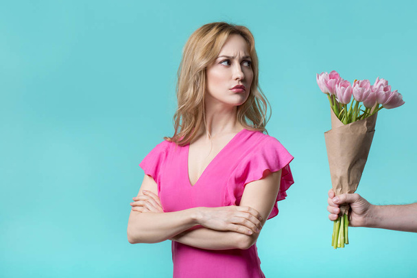 Resentful young woman receiving flowers apology - 写真・画像