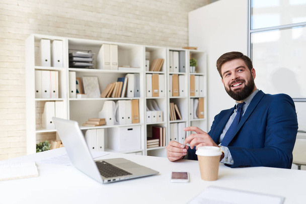 Portrét úspěšných vousatý podnikatel šťastně se usmívala při práci v moderní kanceláři - Fotografie, Obrázek