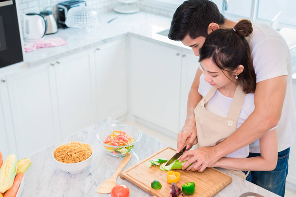 Top view of Asian lovers or couples cooking breakfast in the morning in kitchen room. Man teaching woman to slice vegetable and rice. Relationship and Family concept. Honeymoon and Holidays theme - Foto, immagini