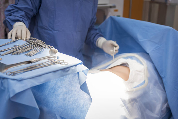 Лікарі з інструментами в руках роблять операцію в операційній. Концепція охорони здоров'я та лікарні
 - Фото, зображення
