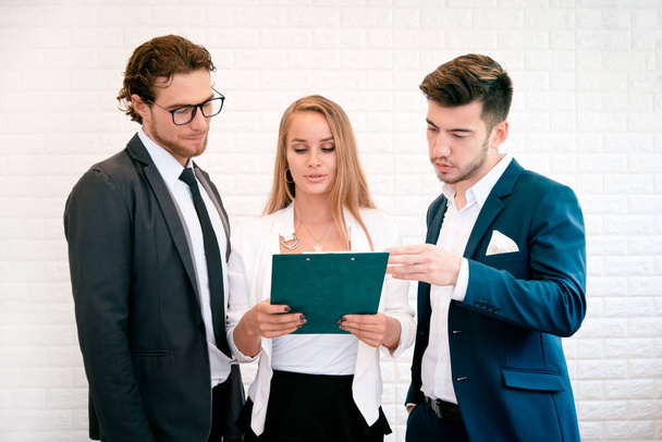 Three business people are looking at the summary report and consult together, Indoors  Businessman and Businesswoman concept, Meeting and consulting concept - Photo, Image