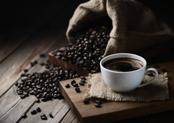 tazas de café y granos de café en una mesa de madera
 - Foto, imagen