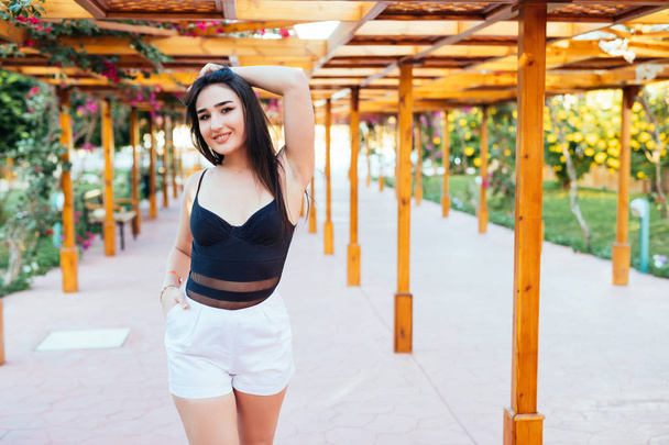 Fashion stylish trendy sensual portrait of pretty young woman posing outdoor in summer in the beach cafe having fun - 写真・画像