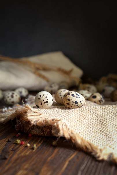 Перепелиные яйца на салфетке на деревянном столе
 - Фото, изображение