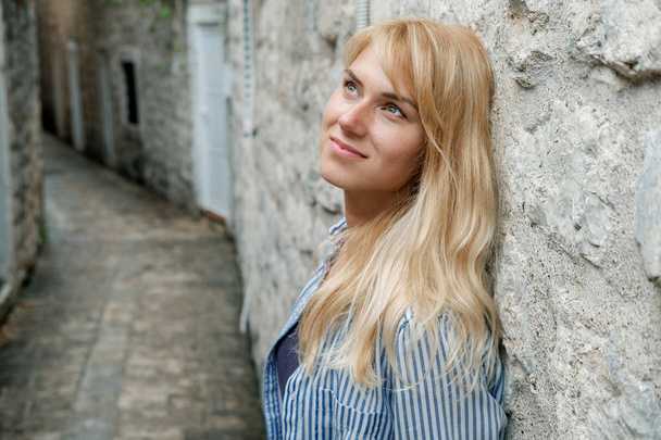 Portret podróżnika blond kobieta spaceru na starym mieście i podziwiając widoki w lato. Czarnogóra - Zdjęcie, obraz