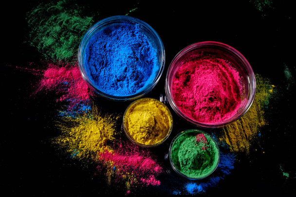 Indian Holi festival colours in four bowls on dark background. - Фото, изображение