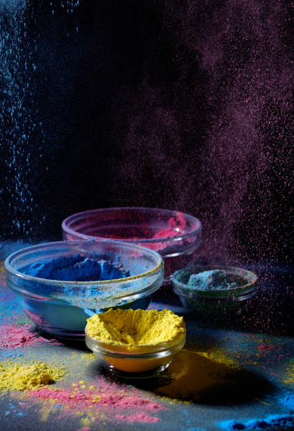 Indian Holi Festiwal kolorów. Kilka misek z Holi farby w proszku. Wybuch od kolor fioletowy i niebieski. - Zdjęcie, obraz