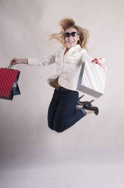 woman with a jacket in sunglasses with packages for purchases studio - Photo, Image