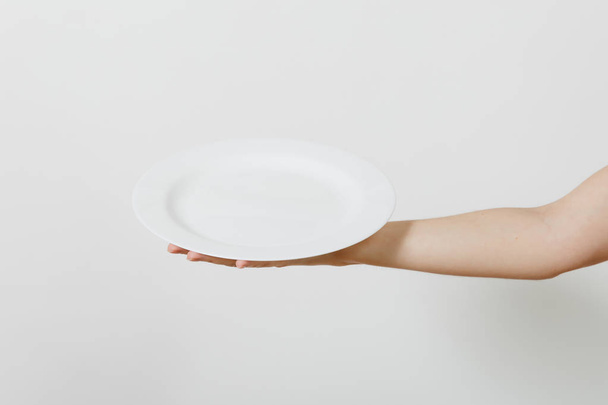 Close up da mão feminina horizontal segurando placa redonda branca isolada no fundo branco. Utensílios de cozinha conceito. Espaço de cópia para propaganda
. - Foto, Imagem