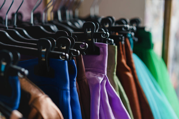 Stand con appendini con vestiti colorati nello showroom
 - Foto, immagini