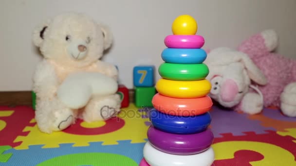 Çocuk oyuncakları yere dağılmış. Çocuk plastik renkli piramit. - Video, Çekim