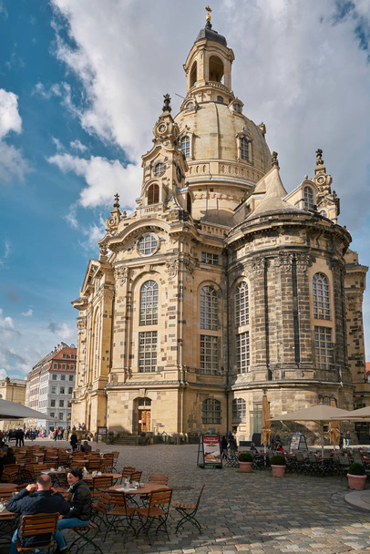 DRESDEN, GERMANY  OCTOBER 12, 2017: Frauenkirche in the old town of Dresden. In the foreground some tourists are sitting in a Restaurant - Photo, image