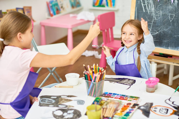 Retrato de dos niñas disfrutando de clases de arte y artesanía en la escuela de desarrollo y divirtiéndose
 - Foto, imagen