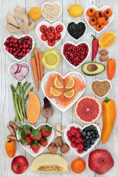 Az egészséges szív lazaccal, zúzott jég, gyümölcs, zöldség, dió, magvak, gyógynövények, fűszer és olívaolaj, élelmiszerek magas omega-3 zsírsavak, antioxidánsok, antocianinok, rost, vitaminok és ásványi anyagok az élelmiszer-egészségügy, - Fotó, kép