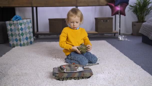 Vakava poika oppii pelaamaan kaukosäädin lelu
 - Materiaali, video