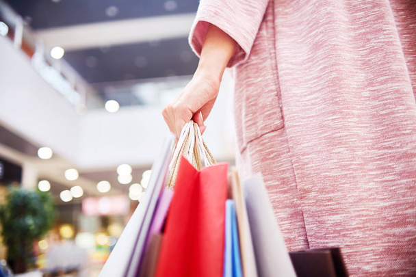 lähikuva nuori nainen tilalla paperipussit ostoksilla ostoksia ostoskeskuksessa
 - Valokuva, kuva