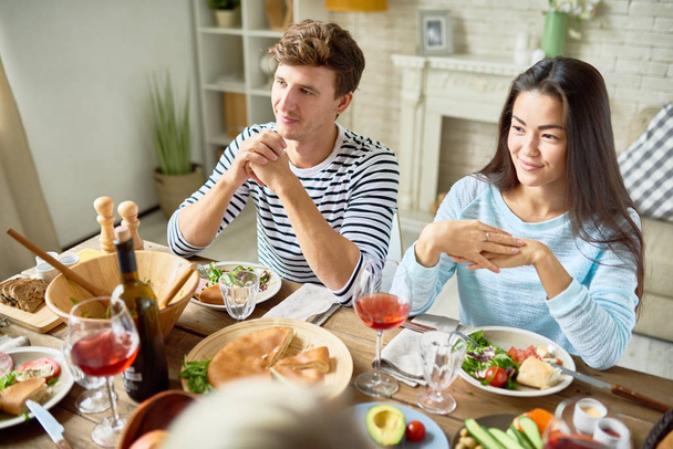 食品の友人と夕食を食べていると幸せ祝う休日を笑顔と大きなテーブルに座っている 2 人の現代若者の肖像 - 写真・画像