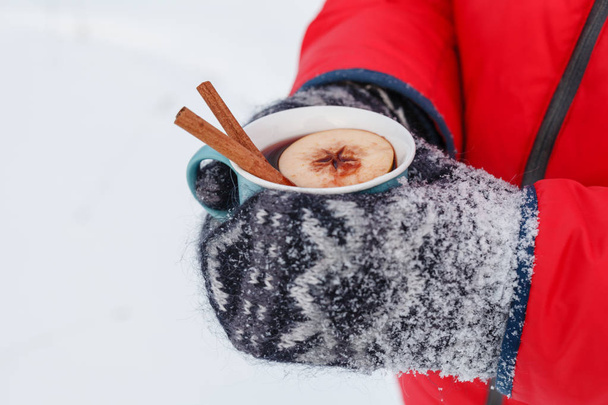 winter hot drink in forest, mulled wine in hands - Photo, Image