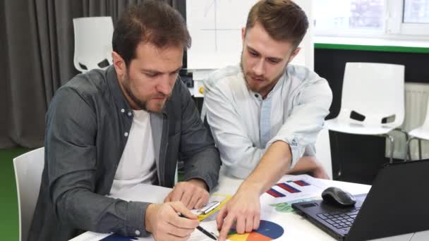 Hombres colegas de negocios haciendo papeleo juntos en la oficina
 - Imágenes, Vídeo