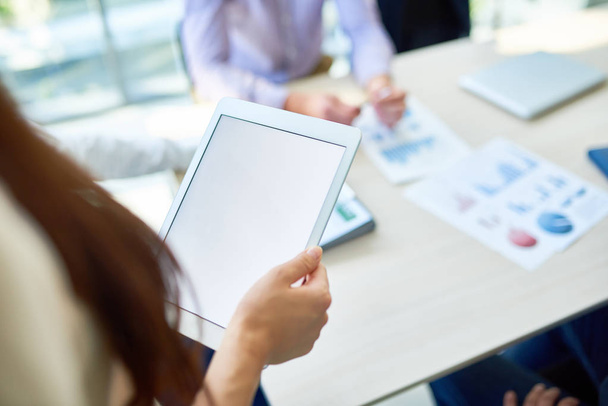 Close up de jovem segurando tablet digital com tela branca em branco ao dar apresentação durante reunião no escritório moderno, espaço de cópia
 - Foto, Imagem