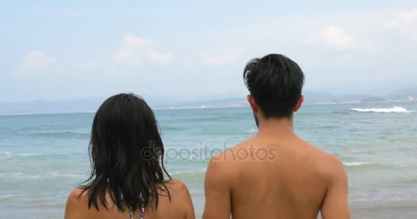 Aasialainen pari kävelee kohti kaunista merta
 - Materiaali, video