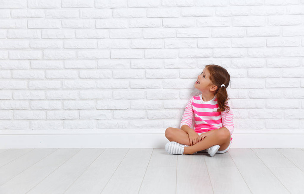 bambino felice ragazza vicino a un muro di mattoni vuoto
 - Foto, immagini