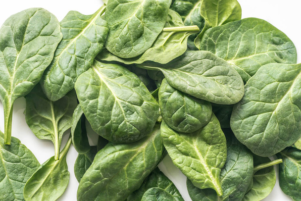 raw spinach leaves on white plate - Foto, afbeelding
