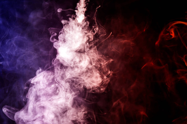 Espeso humo colorido de colores azul y púrpura sobre un fondo negro aislado. Fondo del humo del vapor
 - Foto, Imagen