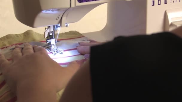 Una costurera prepara una máquina de coser, cose la tela, el plan de vuelta
 - Metraje, vídeo
