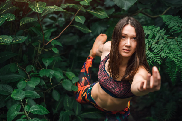 Приваблива жінка робить мудра і вправи з балансу йоги в джунглях
 - Фото, зображення