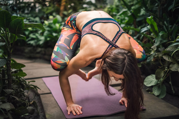 Primer plano de una instructora de yoga haciendo ejercicios en el invernadero
 - Foto, imagen