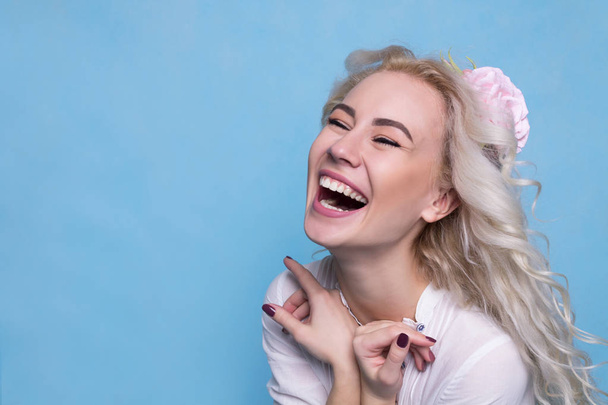 Beautiful young girl with flower in hair laughing. Copy Space - Фото, зображення