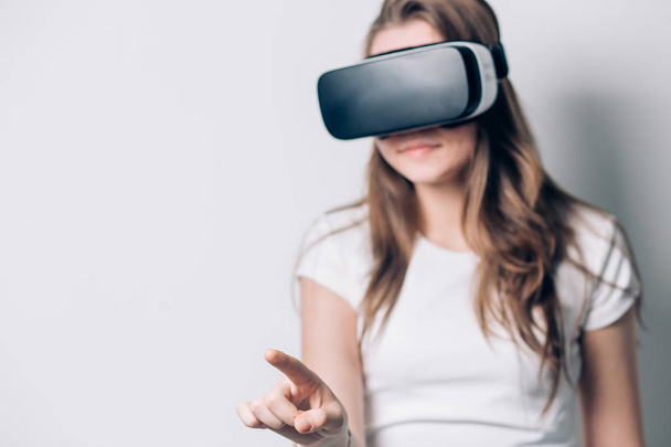 Young woman playing game in virtual reality glasses, VR headset glasses device. - 写真・画像
