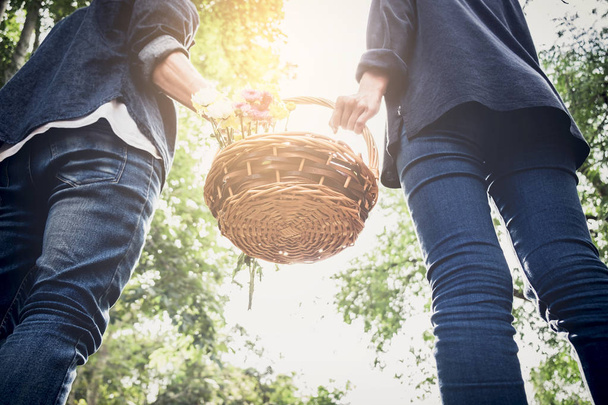 Couple in love walking and holding a picnic basket on nature out - Photo, Image