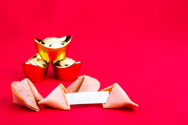 Galletas de la fortuna con pepitas decorativas de oro sobre fondo rojo
 - Foto, imagen