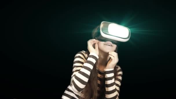 Ragazza adolescente con auricolare VR. Allegro sorridente ragazza caucasica guardando in occhiali realtà virtuale e gesticolando con le mani con molte emozioni diverse dalla paura allo stupore
. - Filmati, video