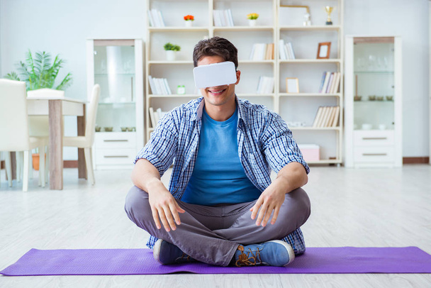 仮想現実を身に着けている男VR眼鏡meditingオン床にホ - 写真・画像
